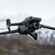 The DJI Mavic 3 Classic drone pictured flying with mountains in the background.
